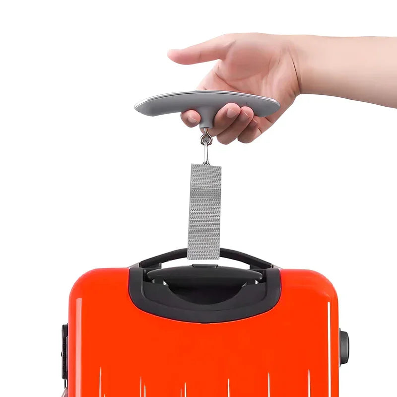Hand lifting orange suitcase with luggage scale for travel weight check